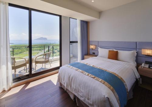 头城兰阳乌石港海景酒店的一间带大床的卧室和一个阳台