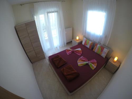 梅塔诺佛希斯Dimi Apartments的一间卧室配有一张带弓的紫色床