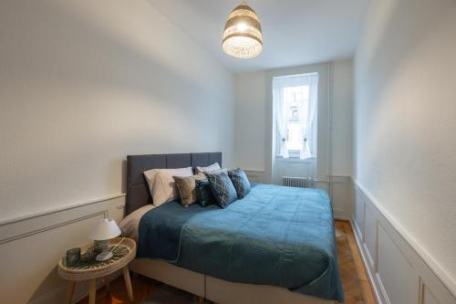 纳沙泰尔V&V CENTRE Neuchatel的一间卧室配有一张带蓝色毯子的床