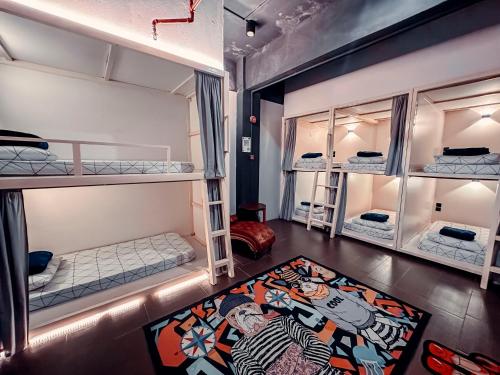 珍南海滩Bed Attitude Hostel Cenang的带三张双层床和地毯的房间