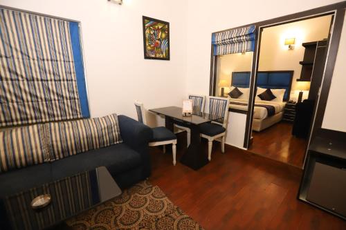 新德里Hotel Capitol Hills - Greater Kailash Delhi的客厅配有沙发、桌子和床。