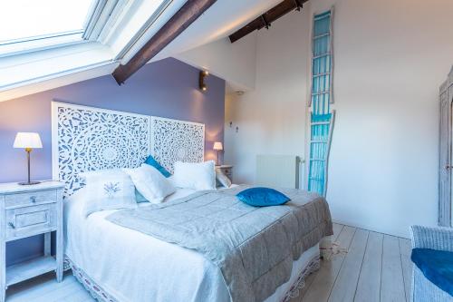 布鲁日B&B Yasmine Brugge的一间卧室配有一张带蓝色枕头的床