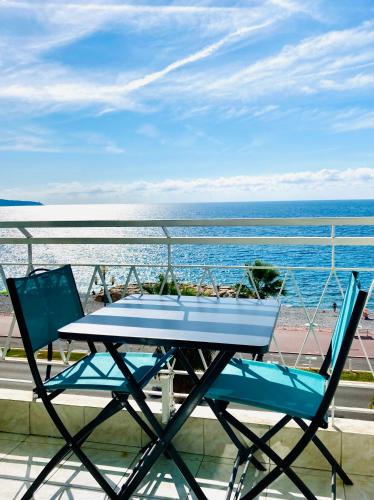 尼斯Residence le Florence的阳台配有一张桌子和两把椅子,享有海景