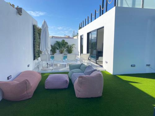 圣巴托洛梅Cap-Canaria FKK的客厅配有紫色和粉色的椅子和一张桌子