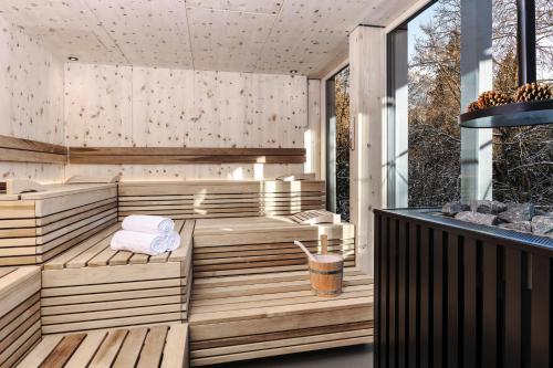 弗利姆斯Romantik Hotel Schweizerhof & Spa的室外桑拿浴室设有木制长椅和毛巾