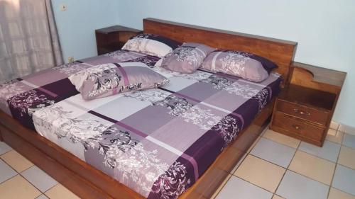 洛美Guesthouse Rotimex的一张木架床和枕头