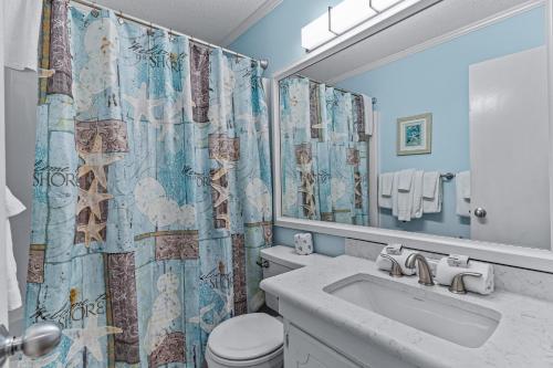 海洋岛海滩Ocean Isle Retreat的浴室配有水槽、卫生间和浴帘