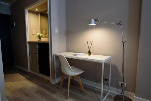 布宜诺斯艾利斯SuMa Recoleta Hotel的一张桌子,椅子和一盏灯放在房间里