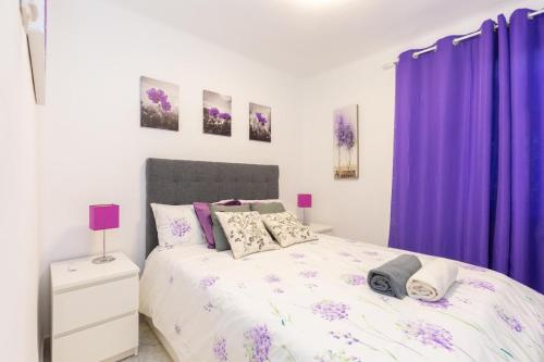 马德里Apartamento Casa de Campo的一间卧室配有紫色窗帘和一张床