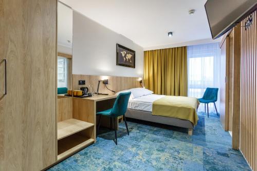 沃姆扎格罗马达沃姆扎酒店的酒店客房,配有一张床、一张桌子和椅子