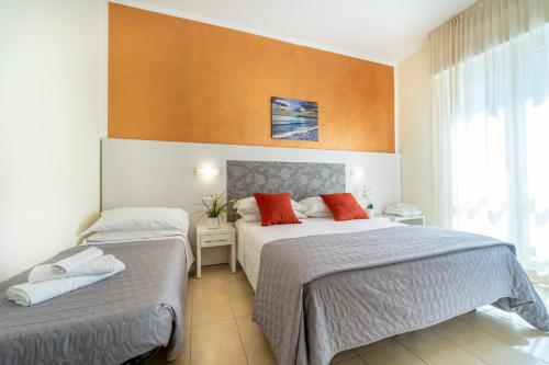 里乔内Hotel Romagna的酒店客房设有两张床和窗户。