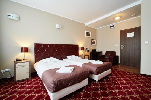 苏瓦乌基Apartamenty-Europejska的酒店客房,设有两张床,铺有红地毯。