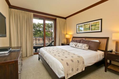 卡波雷Ko Olina Beach Villas B304 - 3BR Luxury Condo with Stunning Ocean View & 2 Free Parking的一间卧室配有一张床、一张书桌和一台电视