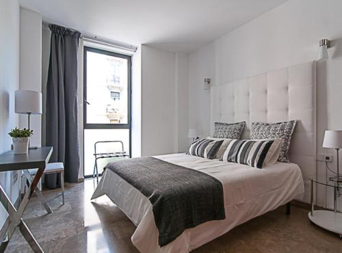 巴塞罗那Picasso Suites 5.1 Paseo de Gracia的白色的卧室设有一张大床和一个窗户