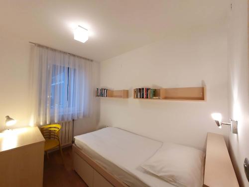 卢布尔雅那Apartment Eva Tour As Ljubljana的一间卧室配有一张床、一张书桌和一个窗户。