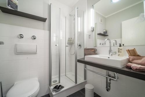 汉堡Auszeit Hotel Hamburg的白色的浴室设有水槽和淋浴。