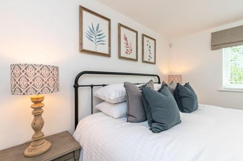 巴拉顿Oxfordshire Living - The Sunderland Apartment - Bladon的一间卧室配有带枕头和台灯的床