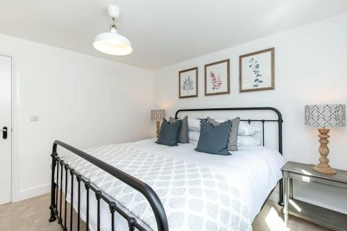 巴拉顿Oxfordshire Living - The Sunderland Apartment - Bladon的一间卧室配有白色床和蓝色枕头