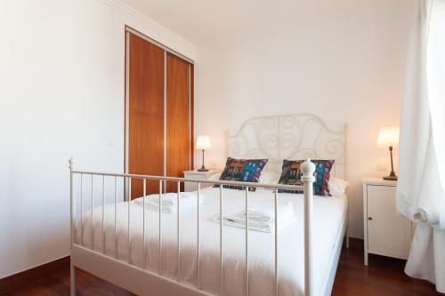里斯本FLH Expo Cozy Apartment的一间卧室配有一张白色床架的床