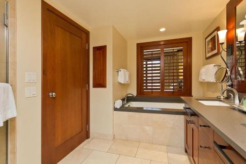 卡波雷Ko Olina Beach Villas O410 - 2BR Luxury Condo with Partial Ocean View的浴室配有盥洗盆和浴缸。