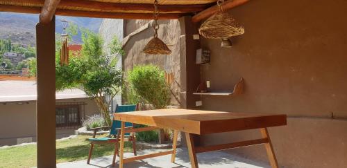 蒂尔卡拉La Casa de los Molles的房屋前的一张木桌和椅子