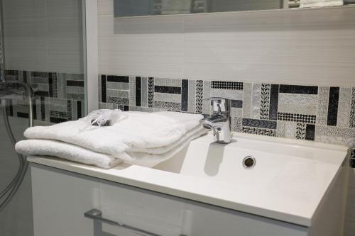 比亚里茨维多利亚冲浪酒店的浴室设有水槽和毛巾