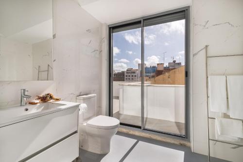 里斯本Succeed Campo Pequeno Apartments的白色的浴室设有卫生间和窗户。