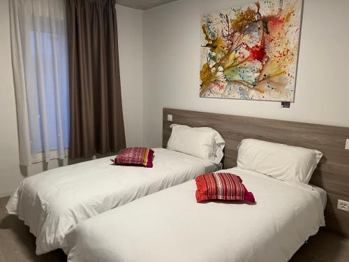 阿格诺Regina Bed & Breakfast的配有白色床单和红色枕头的酒店客房内的两张床