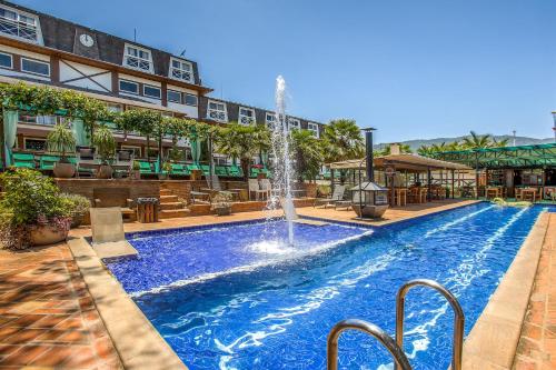 伊克斯雷玛Hotel Villa Lobos Spa Romantik的一座建筑中间的游泳池,有一个喷泉