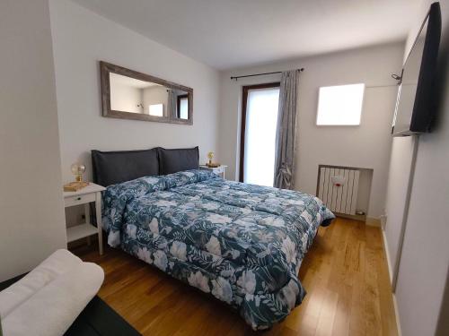 维罗纳L'Ultima Rosa的一间卧室配有一张带蓝色棉被的床和窗户。