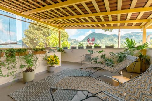 贾丁Hotel Plantación的阳台享有椅子、植物和山脉背景。