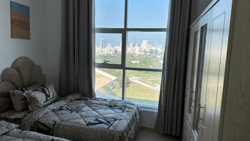 阿吉曼2 bedrooms new brand with amazing view的一间卧室设有一张床和一个大窗户