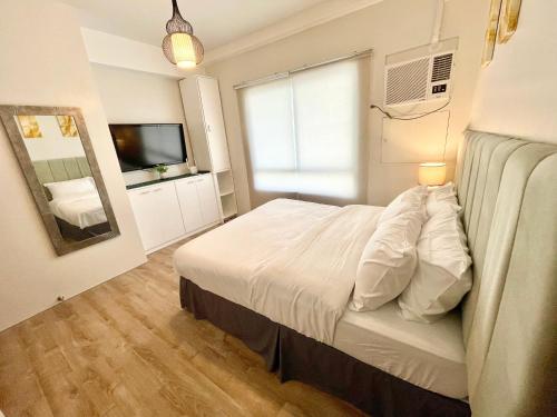巴科洛德One bedroom Condo Suite in Bacolod City的卧室配有白色的床和镜子
