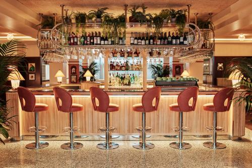 伦敦The Hoxton, Shepherds Bush的餐厅内带棕色凳子的酒吧