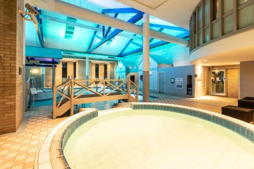 格洛斯特Gloucester Robinswood Hotel, BW Signature Collection的一座大型游泳池,位于一栋拥有蓝色天花板的建筑内