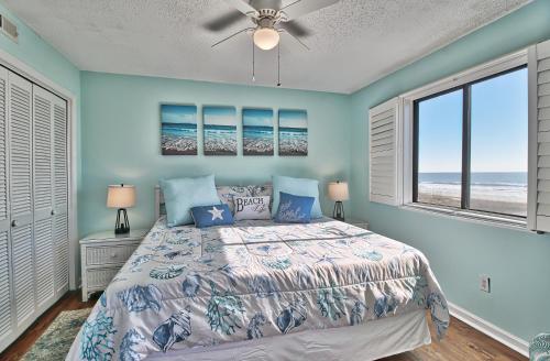 默特尔比奇Direct Ocean Front 3BR/2BA Dog Friendly **OCEANFRONT**的一间卧室设有一张床和两个窗户。