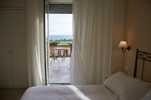 那不勒斯玛格丽特别墅酒店的一间卧室设有一张床,享有阳台的景色