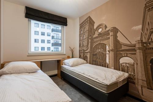 罗兹Luxury Copper Apartment II的卧室设有两张床,墙上挂着壁画