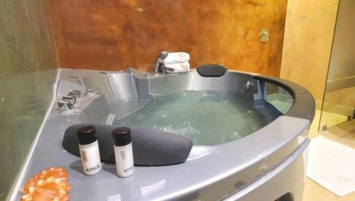基多Hotel Inti Quito的浴缸里装满水,里面装有两瓶