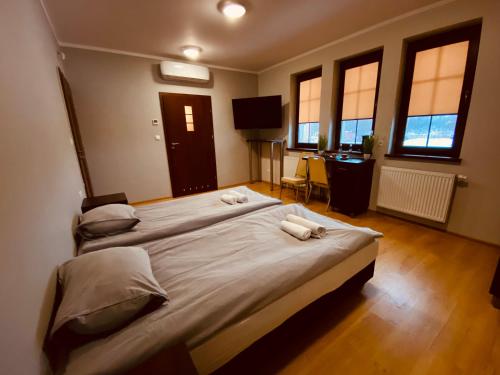 SufczynNasz Młyn的一间卧室设有两张床、一张桌子和窗户。