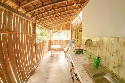 斯勒曼Villa Kampung Ayem Riverside的一间带木墙的客房和一间带水槽的厨房