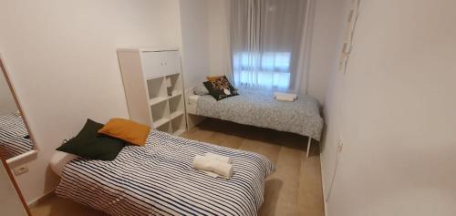 休达Gran piso cerca Centro Comercial y Playa的小房间设有两张床和窗户