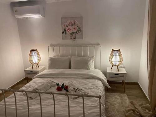 兹拉马Rock House Villa的卧室配有带两盏灯的白色床