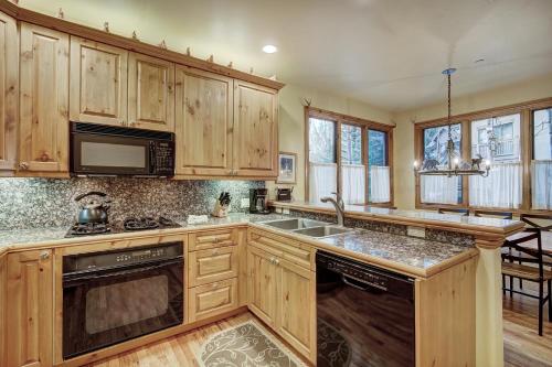 比弗河The Perfect Large Family Retreat condo的厨房配有木制橱柜、水槽和微波炉