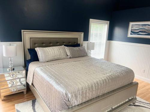克莱蒙Dreamy Family Pool House的一间卧室配有一张带蓝色墙壁的大床