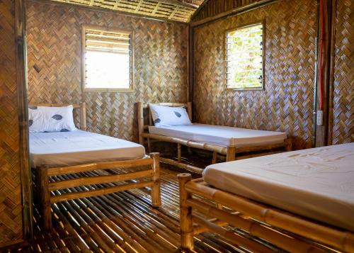 公主港Ocean Green Eco Lodge的一间设有两张床的房间,内设一张长凳