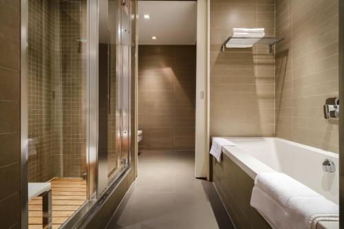 阿拉木图Park Hotel Almaty的设有带浴缸和淋浴的浴室。