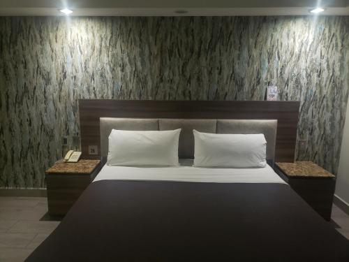 墨西哥城Motel Nuevo Tijuana的一间卧室配有一张带2个床头柜的大床