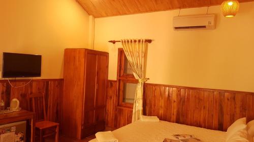 富国Viet Thanh Resort的一间卧室配有一张床和一台电视,另一间卧室配有