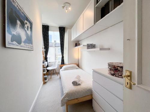 伦敦Beautiful 3BD Flat in Archway London的小房间设有一张床和一张书桌